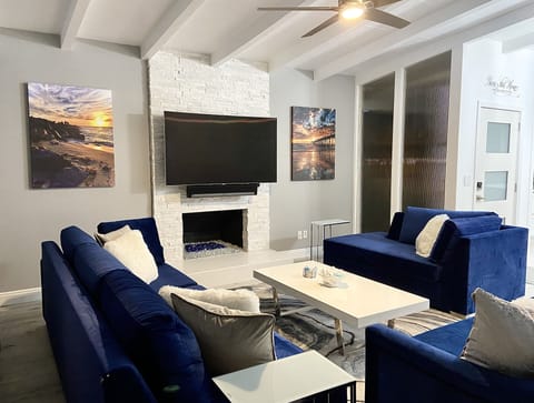 Living room w/ fireplace, ceiling fan, 65" curve TV w/ Sonos soundbar and Roku