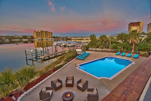 Sunset-lit pool deck w/ lounge chairs overlooking the water