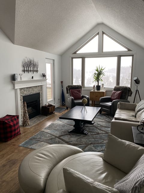 A cozy living room with a fireplace and a large picturesque window.