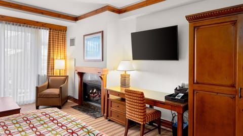 Gas fireplace in sitting area and 55" TV in front of king size bed