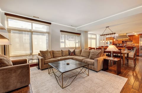 Lowell 402 living room with blinds close and large sectional sofa.