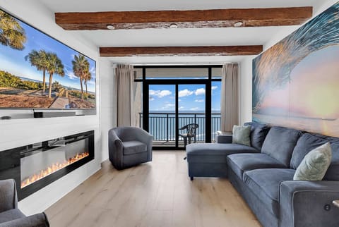 Enjoy the living room space with wooden beams, Alexa-controlled motorized blinds, an electric fireplace, and a 70" LG Smart TV.