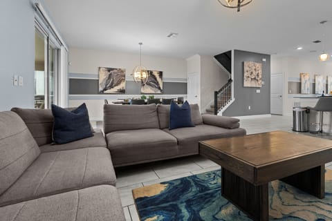 Settle into this stylish living room where plush gray sectional seating and rich wood coffee table create your perfect space for relaxing.