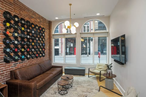 - Stylish living area with exposed brick and vinyl wall art for music lovers   - Large arched windows brighten the room with downtown street views   - Cozy seating creates a relaxing space in this Nashville loft