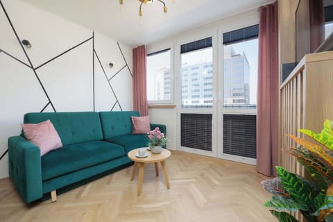 Bright living room with green sofa and balcony access.