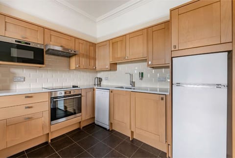 A practical kitchen space with wooden cabinets and all the necessary appliances.