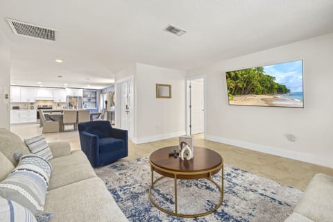 Large open layout with cozy seating, kitchen access, and a mounted TV for added comfort.