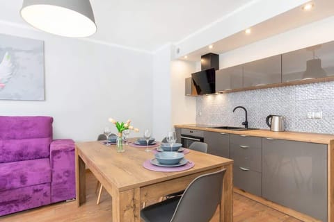 Dining area and kitchenette with an induction hob, kettle, oven and fridge.
