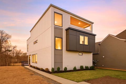 Exterior front of modern white and gray townhouse at dusk