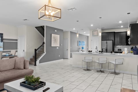 Your modern open-concept space blends kitchen and living seamlessly with sleek countertops, contemporary fixtures, and warm lighting.