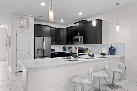 Your sleek kitchen features premium appliances, quartz counters, and modern pendant lighting—perfect for preparing memorable meals during your stay.