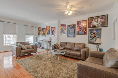 Gather 'round for good times and superhero vibes in this open concept home. Here, the Living Room with arcade table, just steps from the Kitchen Area.