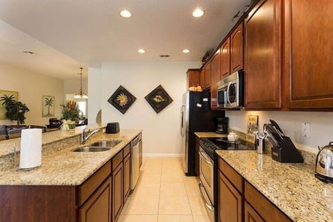 Beautiful kitchen area with microwave, oven, double door refrigerator and barstool seating