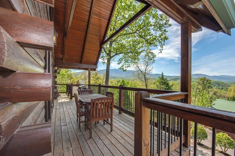Your private mountain-view deck beckons with rustic charm and breathtaking vistas. Sip morning coffee at your wooden table while soaking in panoramic forest views.