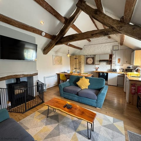 Open plan living space  with log burner at The Cowshed