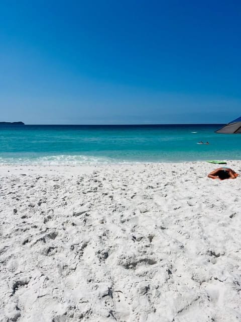 On the beach, white sand, beach umbrellas, beach towels