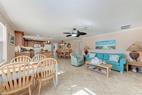 Your spacious open-plan living area combines kitchen, dining, and lounge with coastal décor and comfortable furnishings for perfect vacation relaxation.