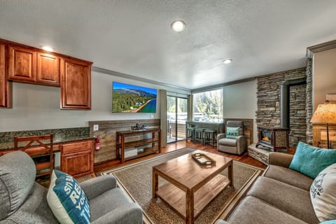 Unwind in your cozy living room with stone fireplace, modern TV, and comfortable seating - perfect for relaxing after mountain adventures.