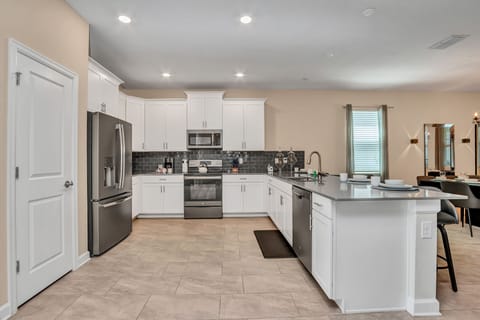 Elegant Kitchen of the Apartment in Florida near Moss Park - Modern kitchen with sleek appliances - Smart use of space with versatile storage solutions - Well-lit space with strategically placed task lighting