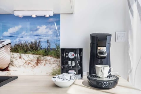 Another angle of the same kitchen or a similar one, showcasing a coffee maker and kettle with a simple backdrop.