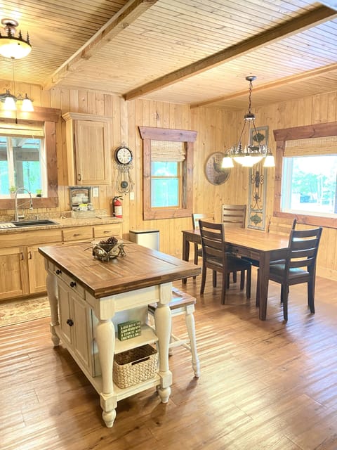 Large kitchen with new appliances, island + kitchen table with six chairs.
