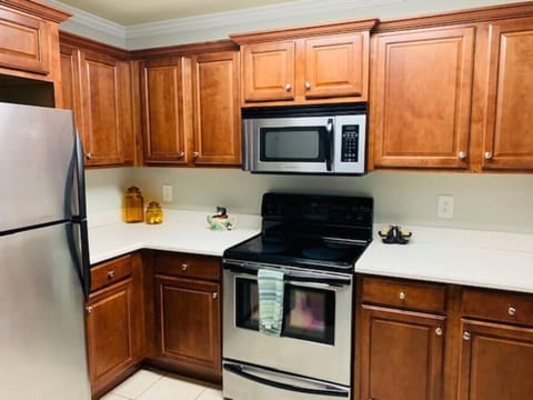 Kitchen with corian countertops, stainless steel appliances and a breakfast bar