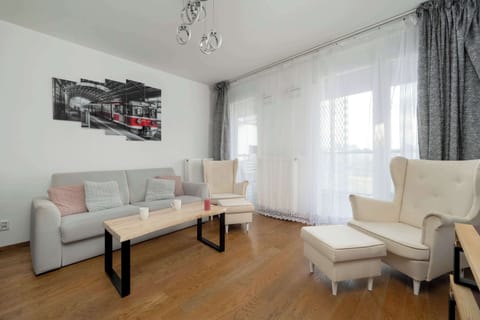 A cozy living space with a soft sofa and large glass doors leading to a terrace, letting in plenty of natural light.