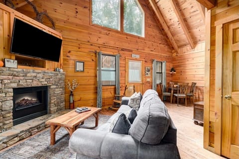 Living room with flat screen TV, electric fireplace, and queen sleeper sofa