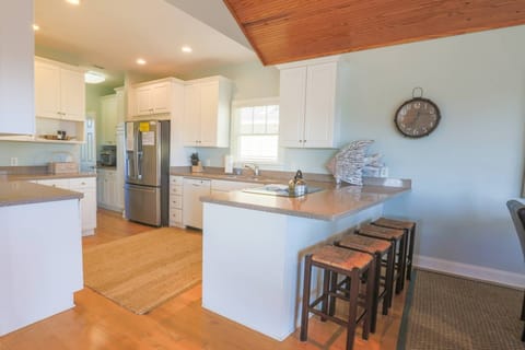 This fully equipped kitchen has granite countertops, white cabinets and an abundance of counterspace.