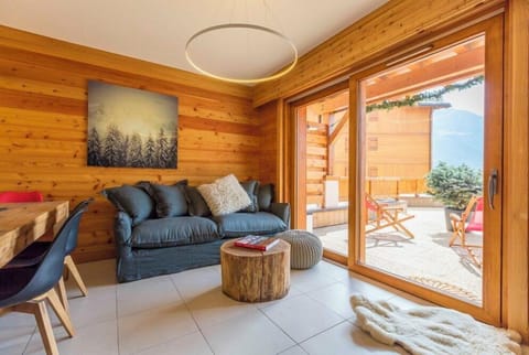 Spacious living room area with sofa, coffee table and beanbags. The patio doors of the lounge area open onto a very large terrace where you can capture the best of the alpine sun while overlooking the slopes.