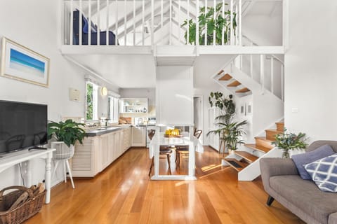 Unwind beside the crackling wood-burning fireplace in the inviting living area, where plush seating, a TV, and an open-plan layout create the perfect setting for cosy evenings in any season.
