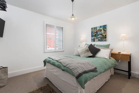 Rest easy in the plush queen bedroom with a mounted TV and hanging space for your belongings