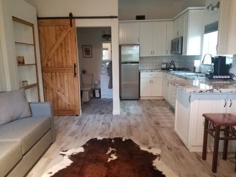 living, kitchen into bathroom and shows couch 