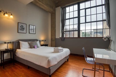 Bedroom 1: Queen-size bed with huge windows overlooking the city
