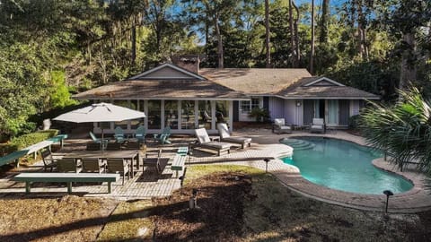 Private retreat nestled among towering trees with sparkling pool and spacious deck for ultimate relaxation.