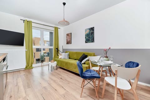 Relax in the stylish living room with a comfortable green sofa and modern decor.