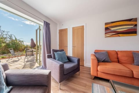 Samphire House, Bodham: Sitting room with doors open to the garden