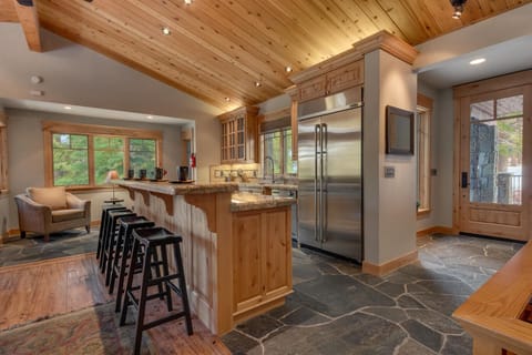 - Gourmet kitchen with stainless steel fridge and stove
- Cabin rental with stone flooring and rustic finishes
- Tahoe mountain home with open kitchen and seating
