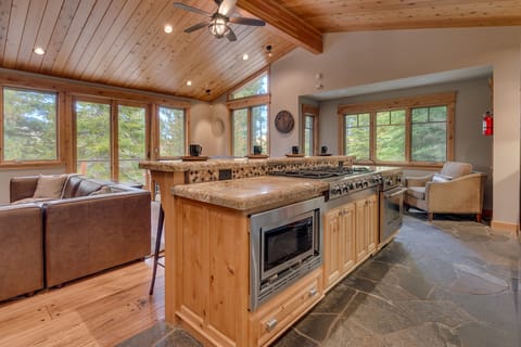 - Kitchen island with stove and modern appliances
- Forest views from open windows and vaulted ceiling
- Mountain vacation rental perfect for cooking together