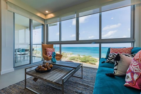 Picture yourself relaxing in your bright living space with floor-to-ceiling windows framing endless turquoise waters and soft white sand just steps away from your door.
