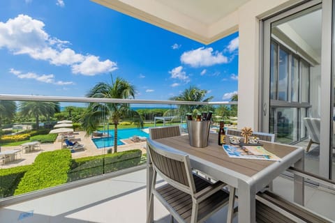 Sip your morning coffee on your private balcony overlooking tropical gardens, sparkling pools, and the vibrant landscape—your peaceful escape awaits just beyond the glass doors.