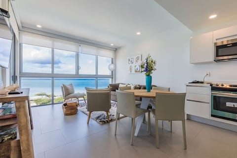 Bright, modern living and dining space with stunning panoramic ocean views—ideal for enjoying meals and watching waves from your private retreat.