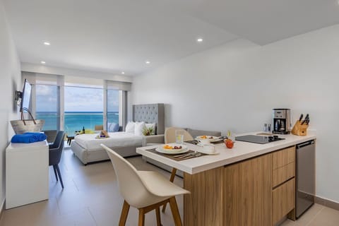 Your modern studio opens to stunning ocean vistas, where morning coffee at the sleek kitchen island flows into lazy beach days. Fresh breezes and turquoise waters are just steps from your door.