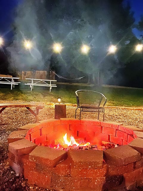 Enjoy the firepit surrounded by lights in the back yard. Seating for 10