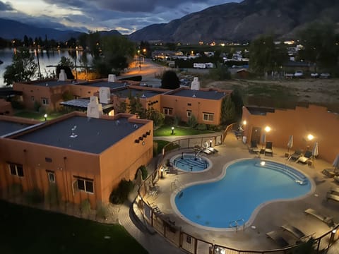 view of pool, lake and mountains at dusk from upper deck