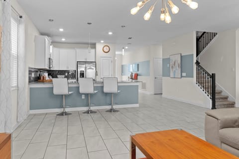 Gather around your stylish kitchen island where morning coffee and evening conversations flow naturally in this bright, modern space.