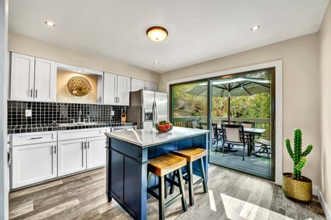 Roomy kitchen overlooks adjacent patio with outdoor dining. 