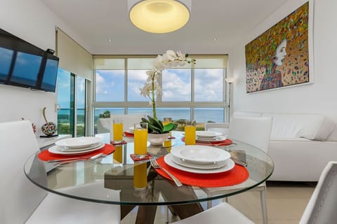 Imagine starting your morning here, where sunlight pours through floor-to-ceiling windows, and the endless ocean stretches before you. A perfectly set breakfast table awaits your arrival, complete with fresh juice and white orchids—designed for relaxation.