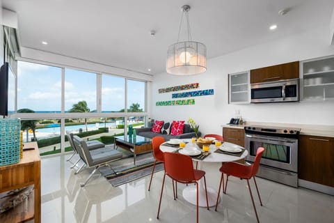 Bright and breezy, your open-concept space connects you with stunning ocean views through floor-to-ceiling windows. Gather around the breakfast table, cook in your fully equipped kitchen, then unwind on the sofa.