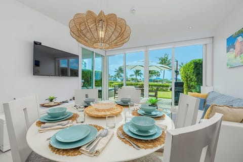 Gather around your bright dining table with tropical views through floor-to-ceiling windows, where meals become moments to remember.